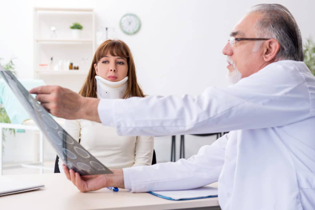 Injured car accident victim receiving medical treatment for whiplash.